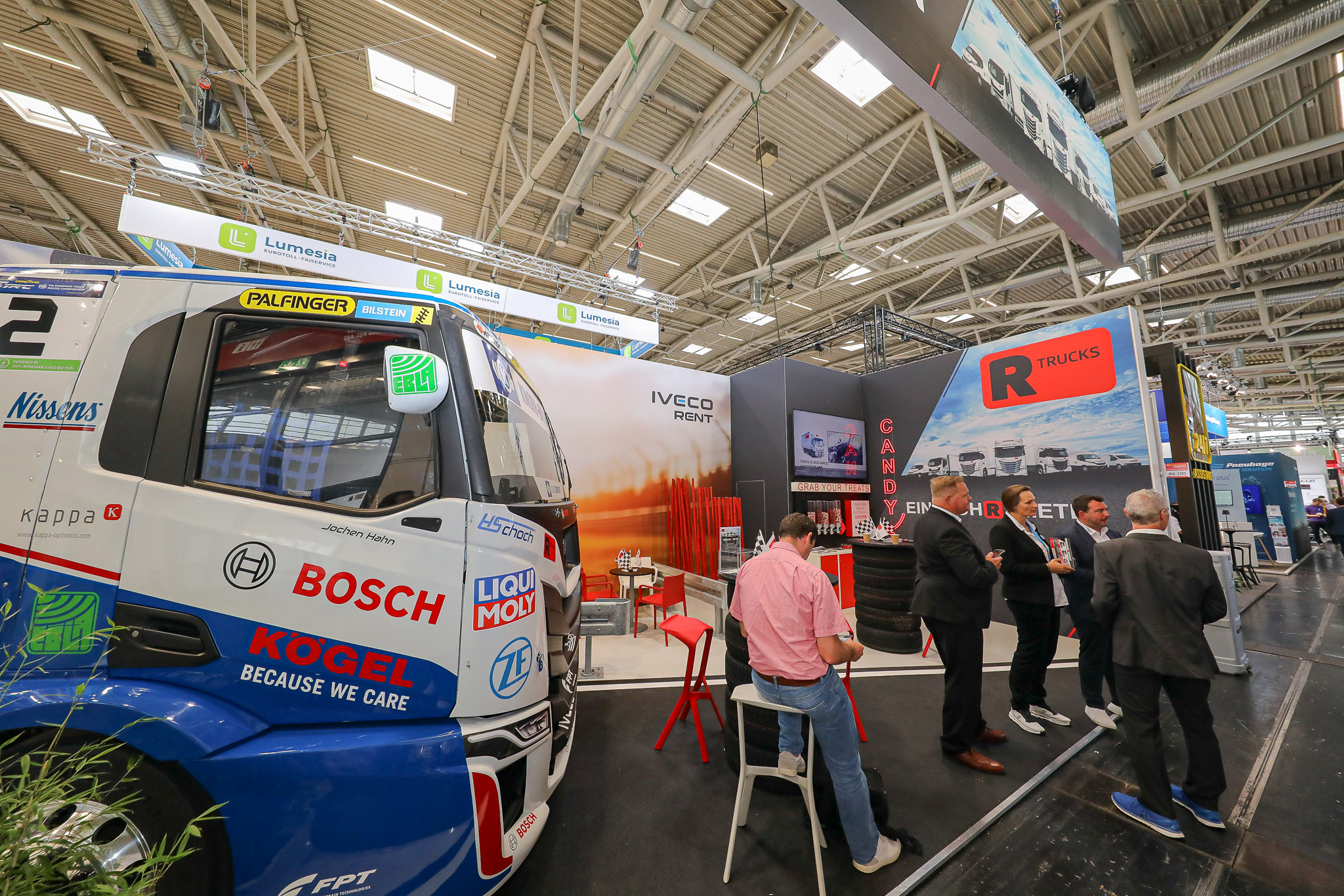 Messestand R-Trucks, ein LKW und mehrere Leute stehen darauf