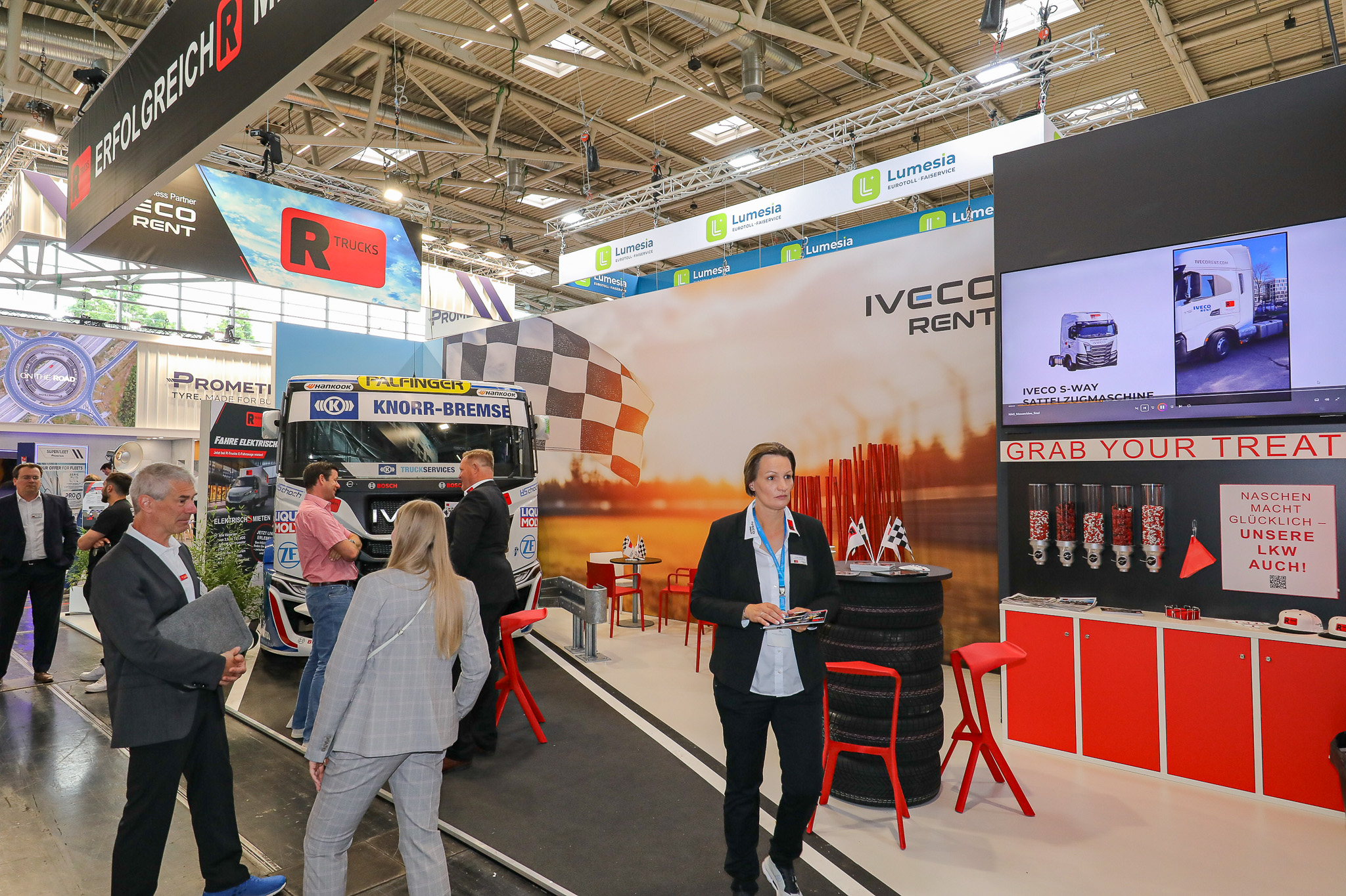 Mehrere Menschen besuchen den Messestand von R-Trucks