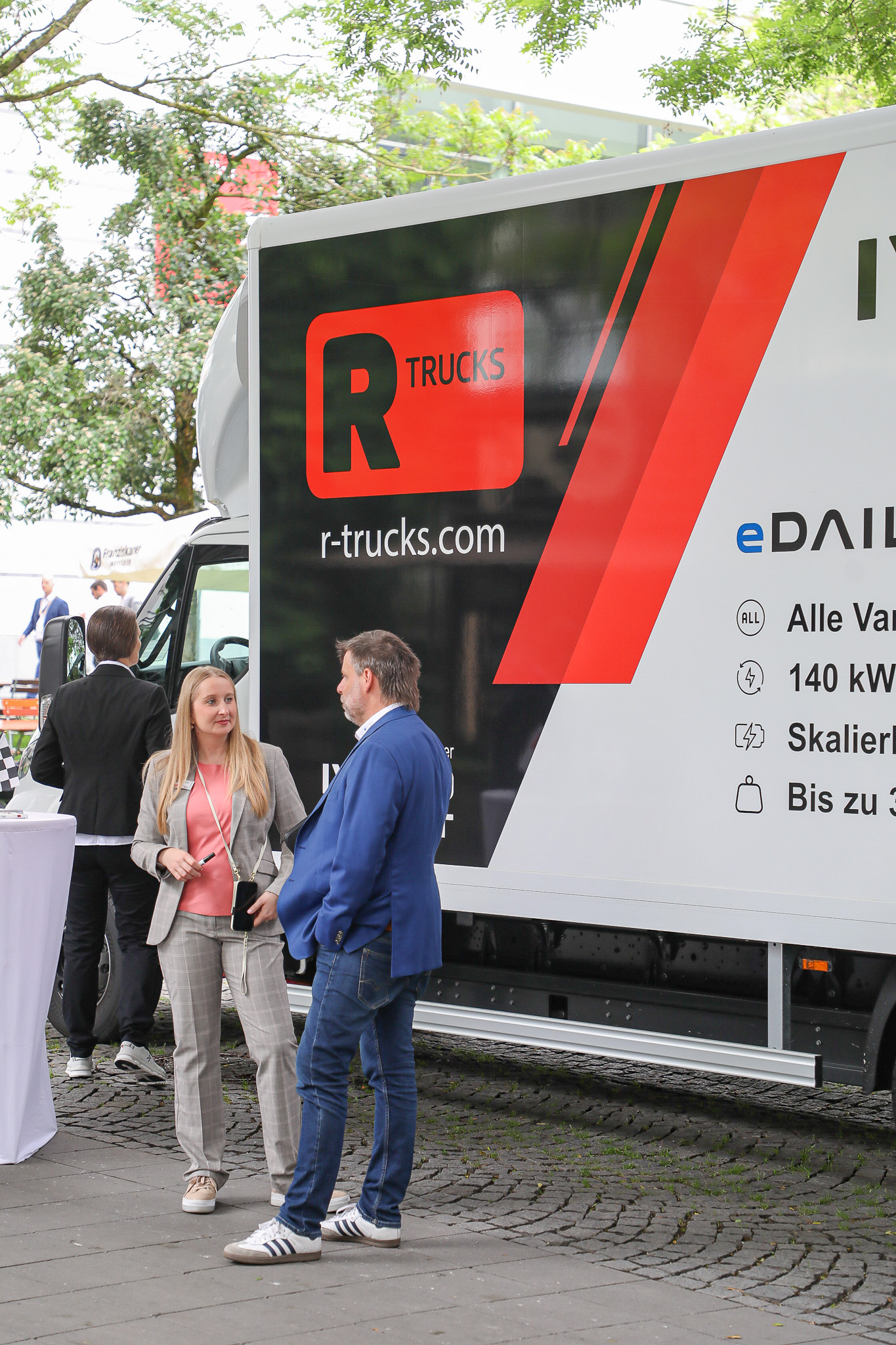 Ein Mann und eine Frau unterhalten sich vor einem Truck