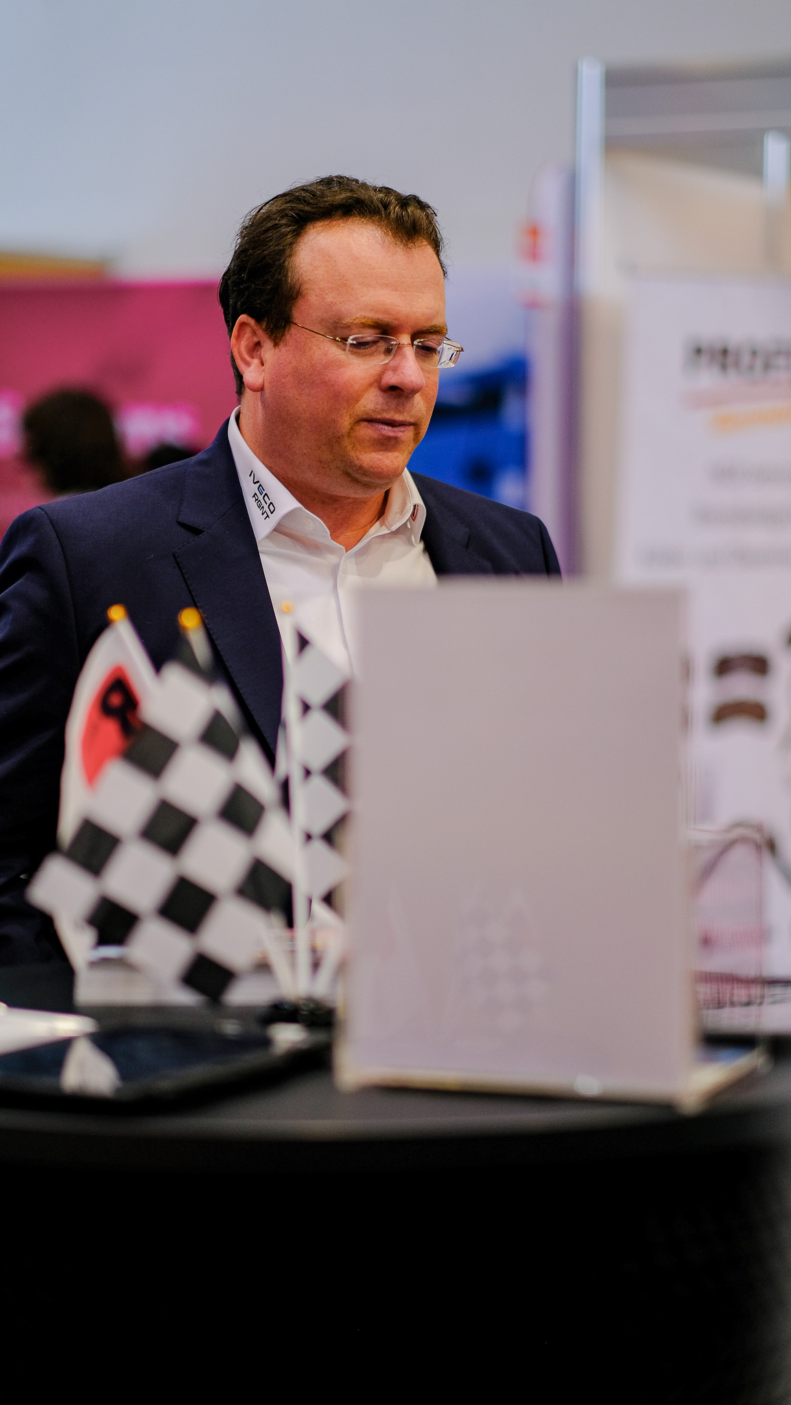 Ein Mann ließt etwas auf dem Messestand von R-Trucks