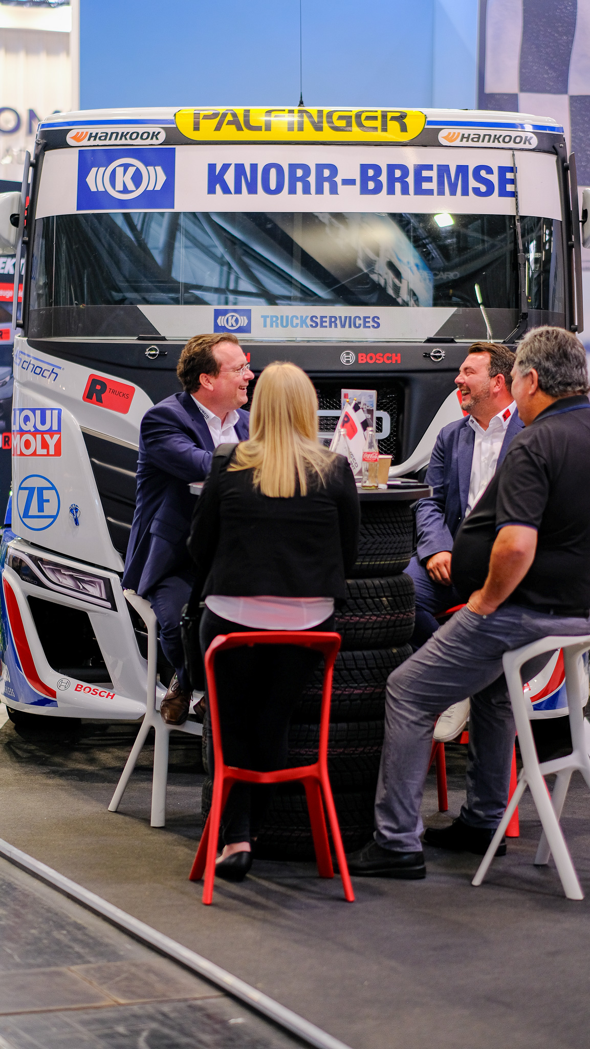 Eine freudige Konversation vor dem Racetruck, der auf dem Messestand von R-Trucks steht